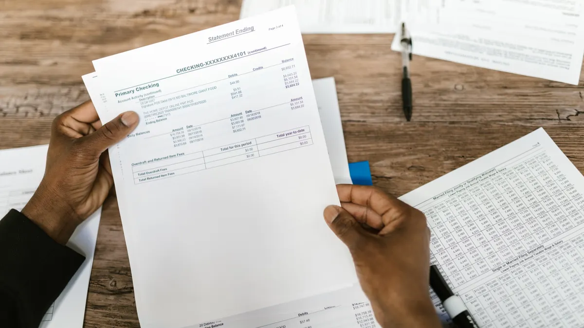 Hands reviewing paper financial statements