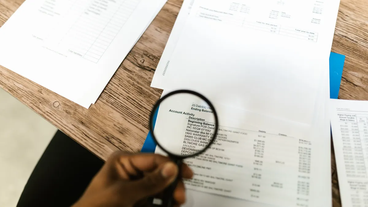 Magnifying glass over account paperwork